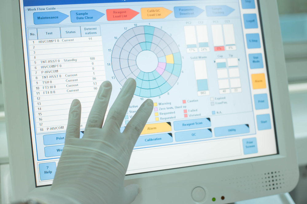 a gloved hand on a computer screen showing data